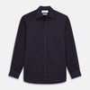 View 3 of product A man stands against a beige background wearing the Turnbull & Asser Navy Weekend Fit Cotton & Wool Shirt with a Derby collar and 1 button cuffs, paired with brown pants and black shoes, looking to the side with a neutral expression.