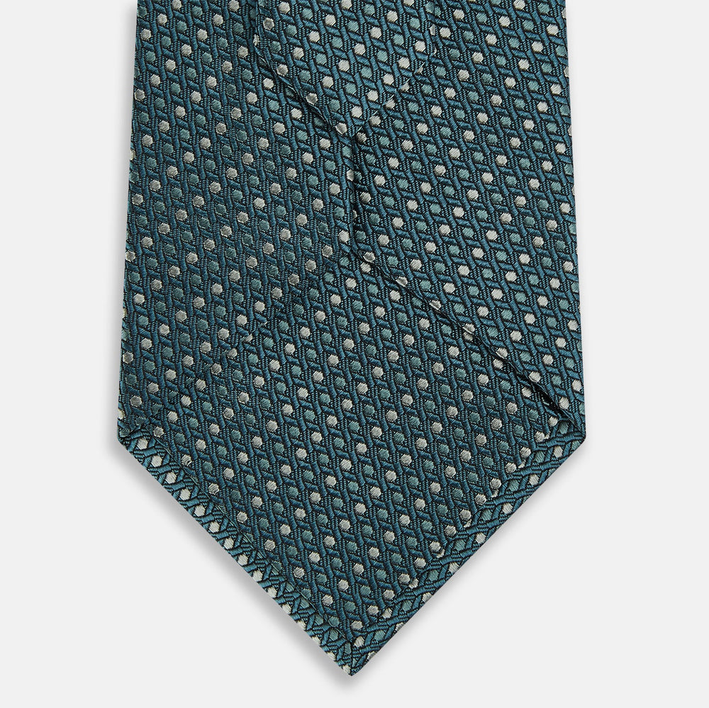 The Turnbull & Asser Teal Micro Hexagon Silk Tie showcases a textured geometric dot and subtle hexagon pattern, adding a refined touch to any tailored look.
