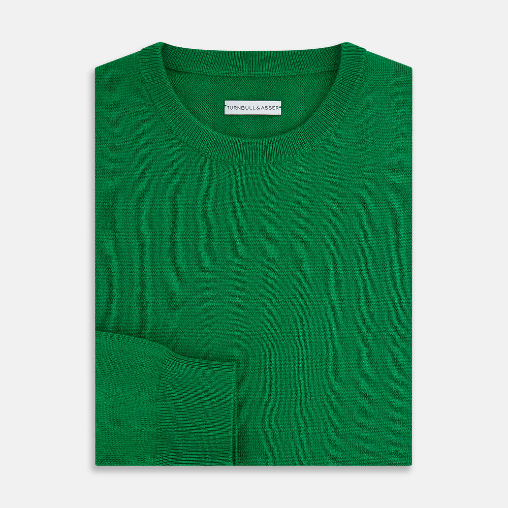The Turnbull & Asser Grass Green Cashmere Round Neck Jumper features long sleeves, ribbed cuffs, collar, and hem, shown on a white background.