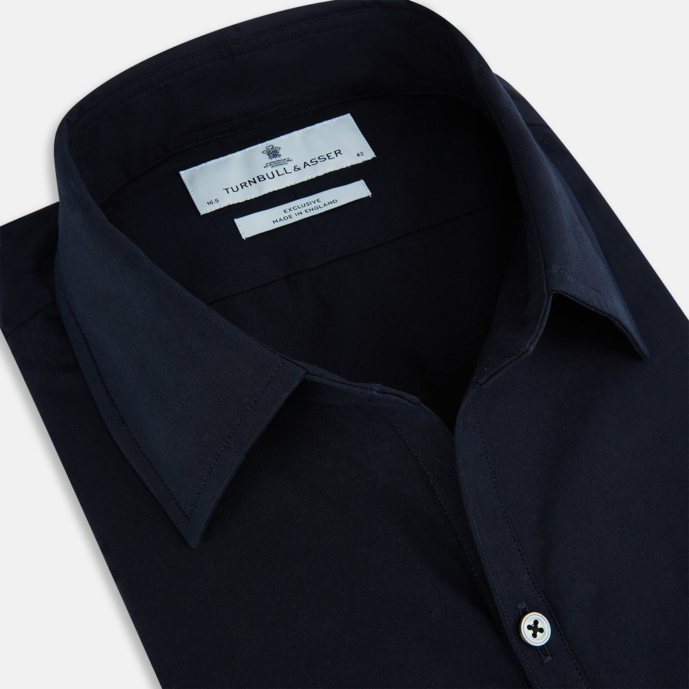 The NAVY BLUE WINDSOR SHIRT by Turnbull & Asser features long sleeves, a classic Windsor collar, white buttons, and buttoned cuffs—highlighting refined British craftsmanship against a plain white background.