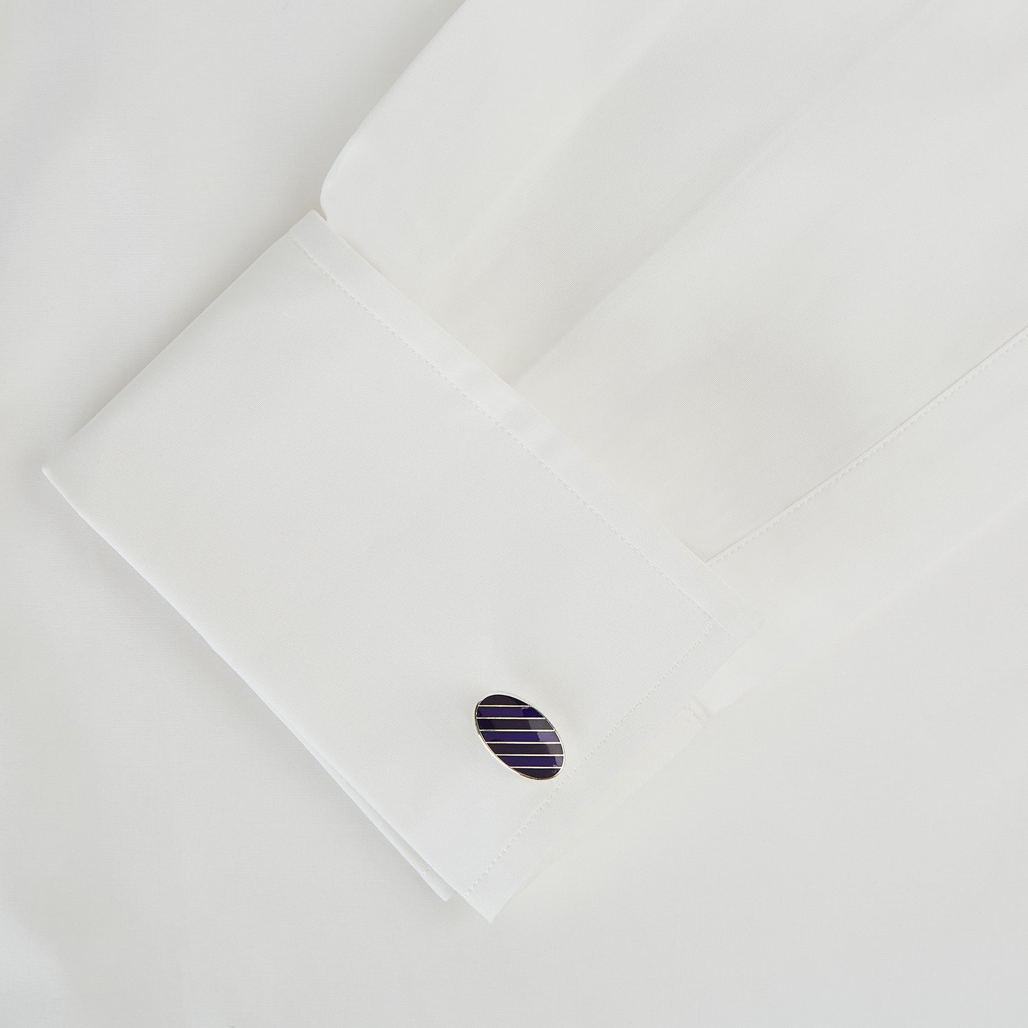 View 3 of product Turnbull & Asser Navy Striped Oval Enamel Cufflinks feature navy blue and black diagonal stripes, shiny silver edges, and a modern oval shape—reflecting masculine elegance in every detail.