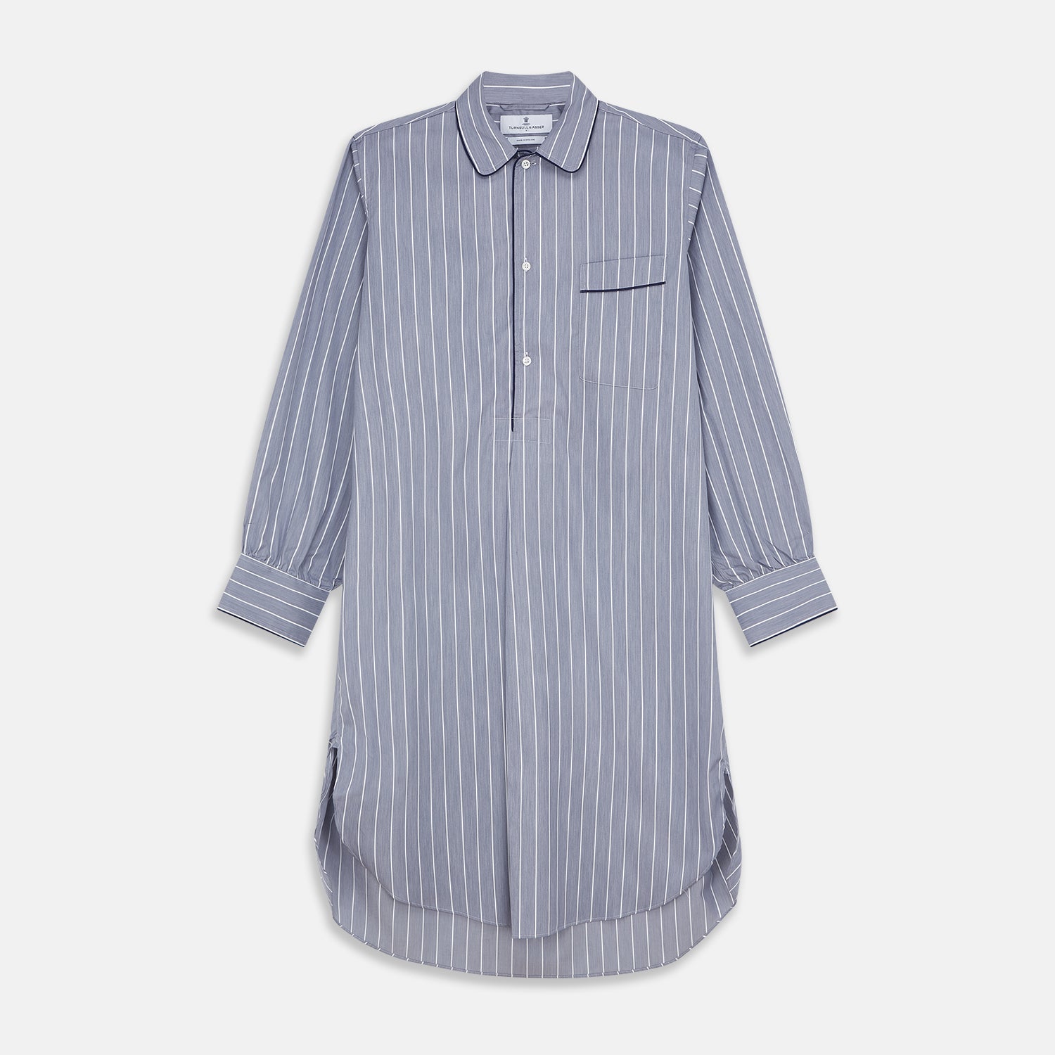 View 1 of product The Turnbull & Asser Pale Blue and White Pinstripe Cotton Blend Sussex Nightshirt pairs classic style with comfort, featuring long sleeves, a collar, front buttons, chest pocket, and curved hemline—perfect for luxury sleepwear.