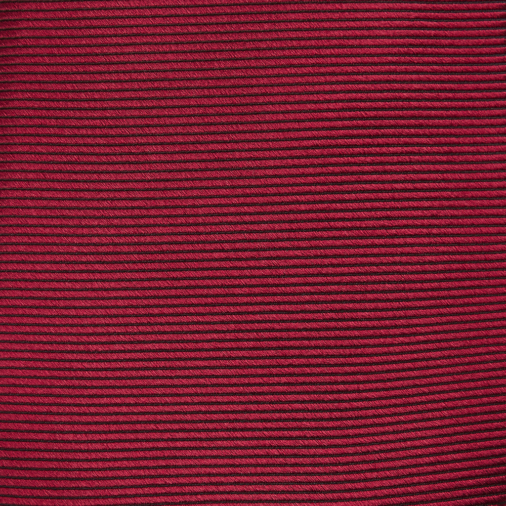 The HORIZONTAL TWILL BURGUNDY TIE by Turnbull & Asser features a subtle textured pattern in solid burgundy, rolled neatly and displayed against a white background—a versatile addition to any gentleman’s wardrobe.