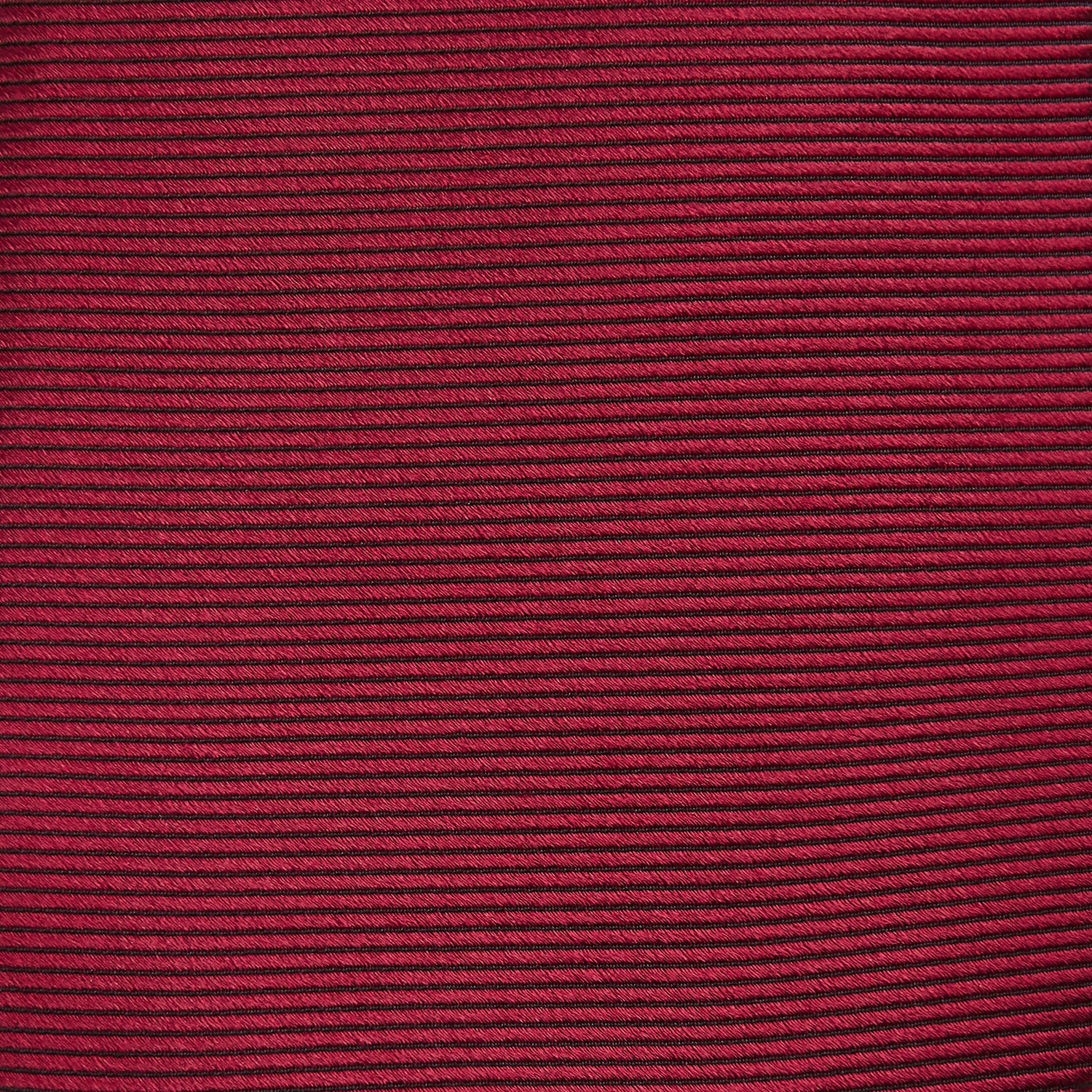 View 3 of product The HORIZONTAL TWILL BURGUNDY TIE by Turnbull & Asser features a subtle textured pattern in solid burgundy, rolled neatly and displayed against a white background—a versatile addition to any gentleman’s wardrobe.