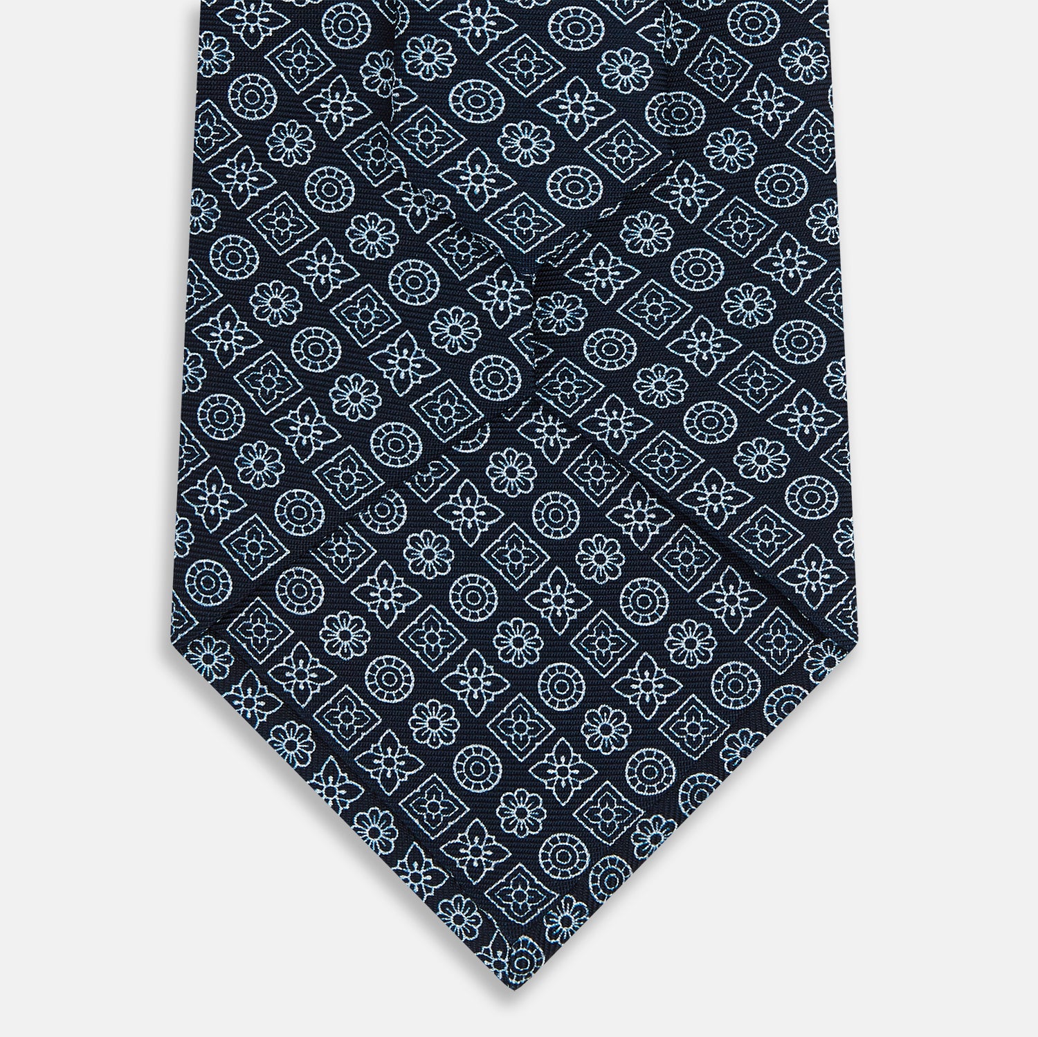 View 3 of product The Turnbull & Asser Navy Floral Tile Pattern Printed Silk Tie features light blue geometric and floral motifs in a diamond grid, elegantly displayed and crafted from fine English silk.