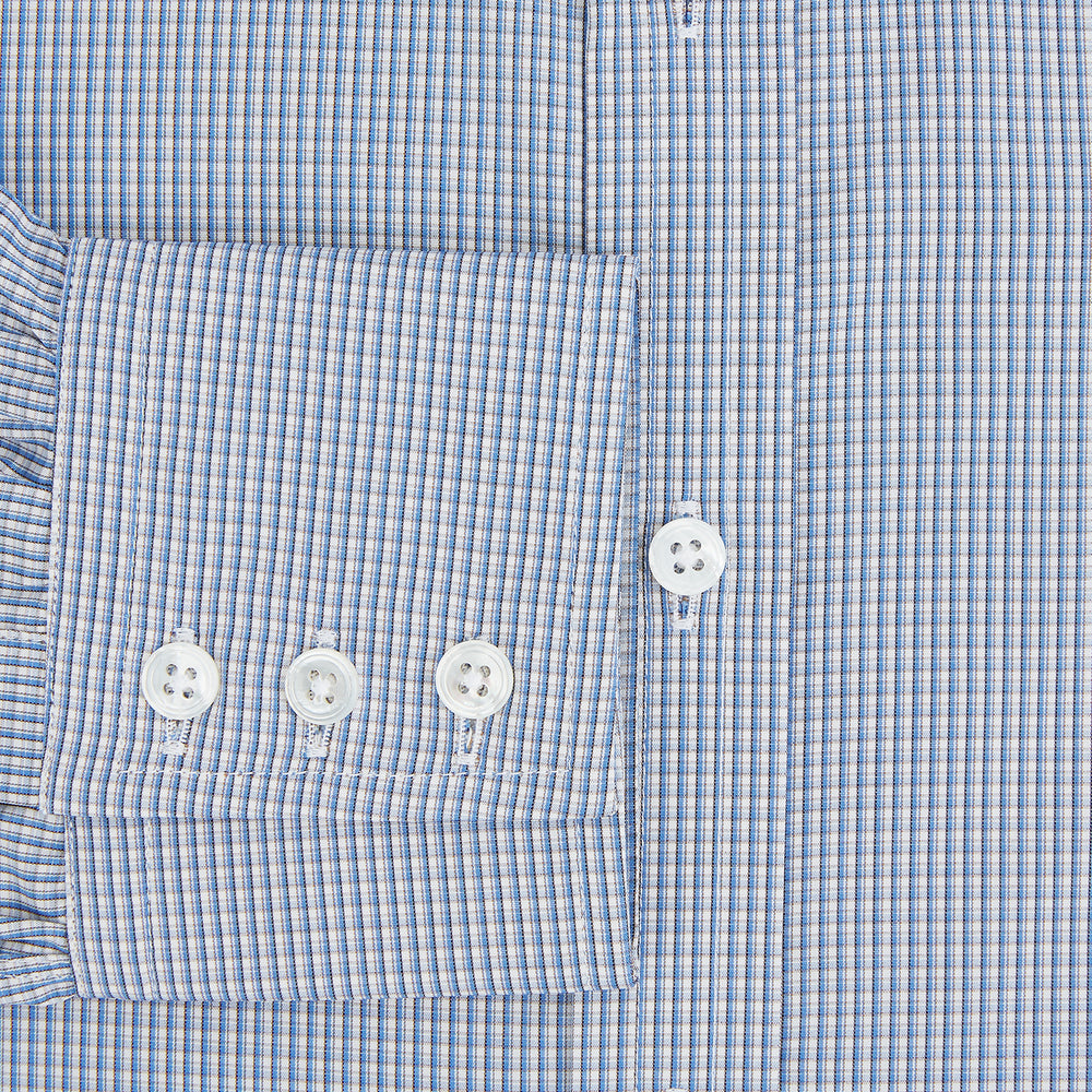 The Turnbull & Asser Pale Blue Micro Graph Check Mayfair Shirt features a small blue and white check pattern, classic T&A collar, white buttons, and buttoned cuffs. Presented on a plain white background.