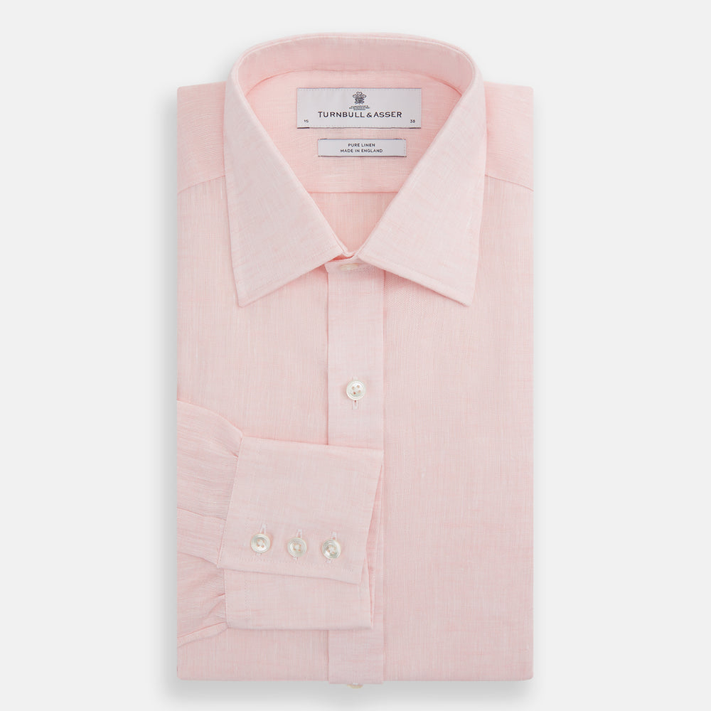 The Turnbull & Asser Pink Linen Shirt features a T&A collar, 3-button cuffs, and classic white buttons. This long-sleeved summer staple is shown on a plain white background.