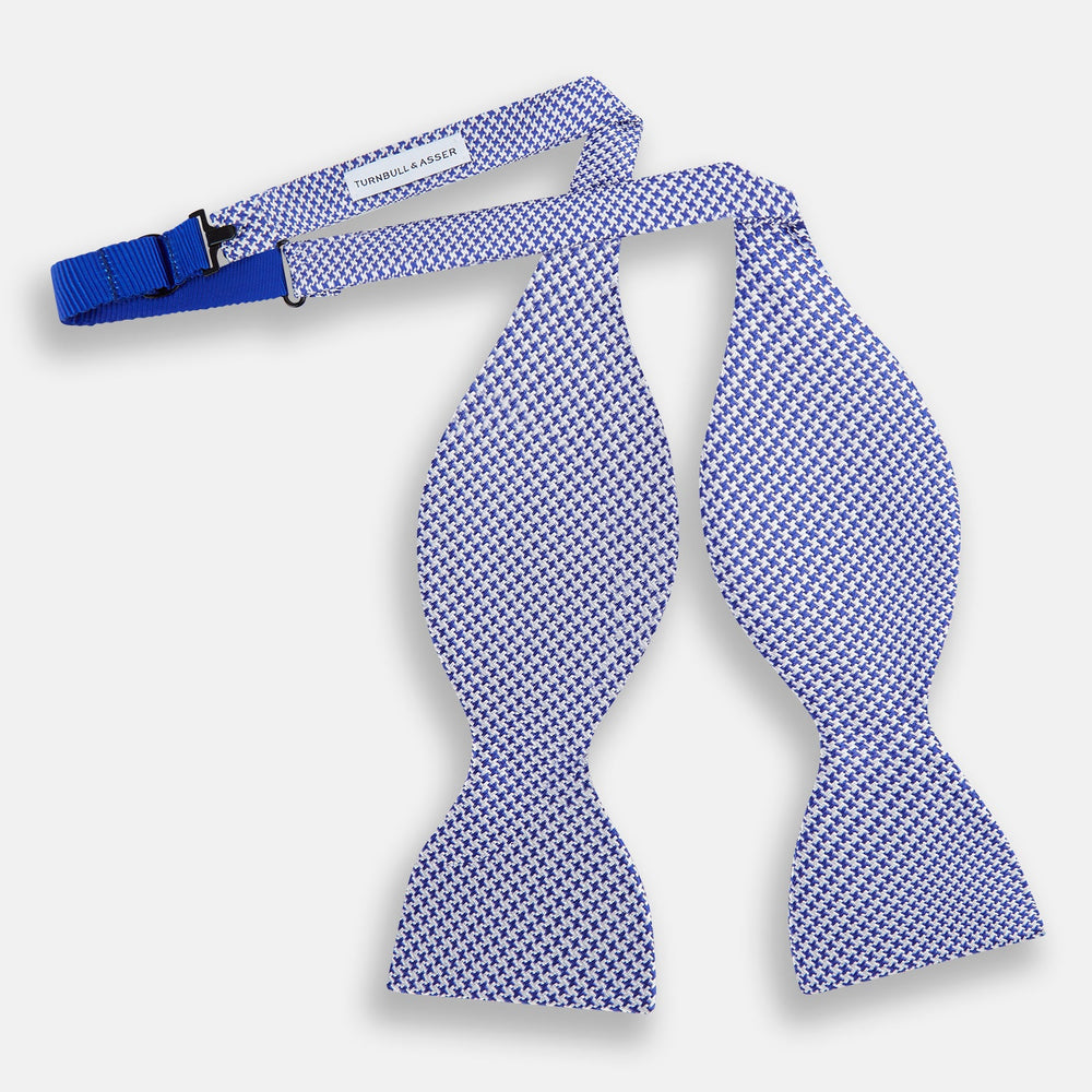 The Turnbull & Asser Navy and White Houndstooth Silk Bow Tie features a neatly centered knot, shown on a white background—an elegant formalwear accessory.