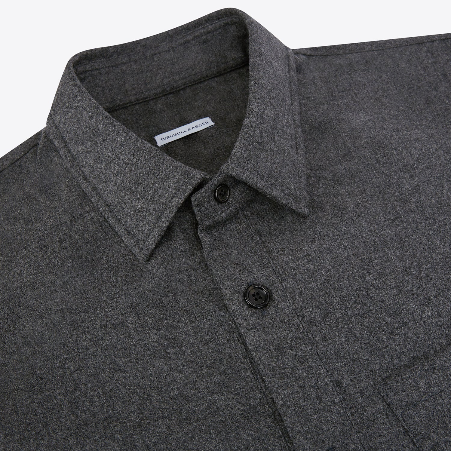 View 2 of product The Grey Highbury Overshirt by Turnbull & Asser is a long-sleeve, button-up charcoal gray overshirt with a single chest pocket, inspired by classic formal jackets and shown laid flat on a white background.