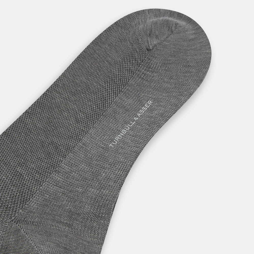 A single Steel Melange Micro Knit Mid-Length Sock by Turnbull & Asser, knee-high and gray, crafted from mercerised Egyptian cotton with a subtle micro knit pattern, is displayed upright on a plain white background.