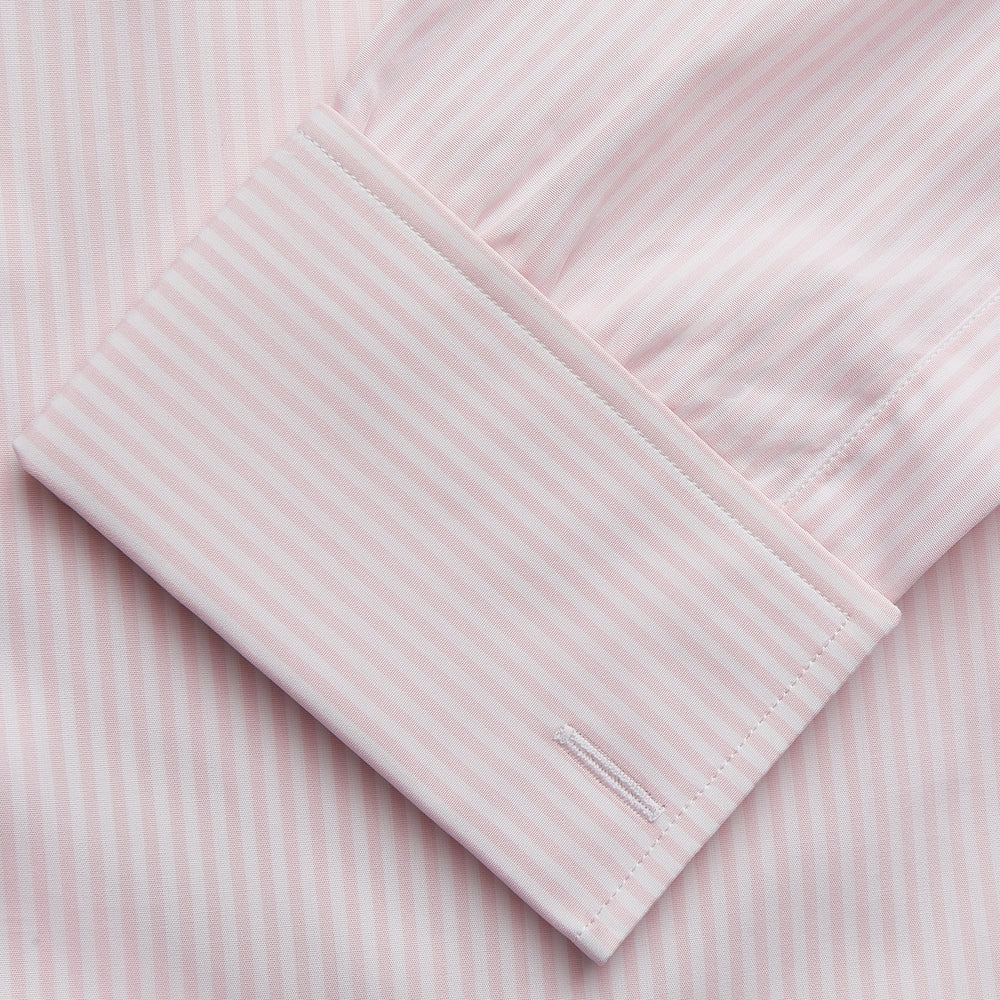 The Turnbull & Asser White and Pink Wide Stripe Shirt with Double Cuffs features a minimalist design, with bold vertical stripes and long sleeves, shown laid flat against a white background.