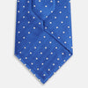 View 3 of product The Turnbull & Asser Blue and White Micro Dot Silk Tie features a subtle herringbone pattern with small white dots, ideal for modern office attire, and is shown rolled up on a white background.