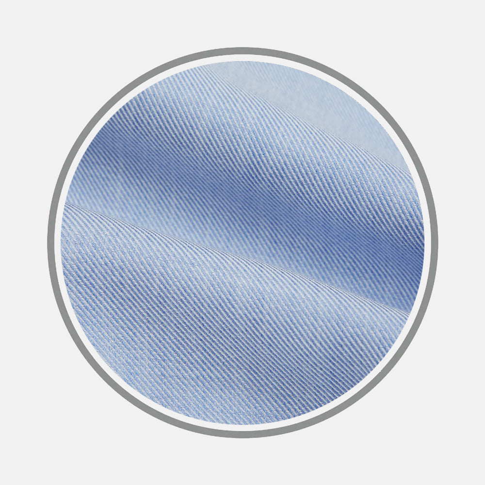 Close-up of Turnbull & Asser's Pale Blue Cashmere Blend Fabric with a diagonal weave, displayed inside a circular frame against a plain white background.