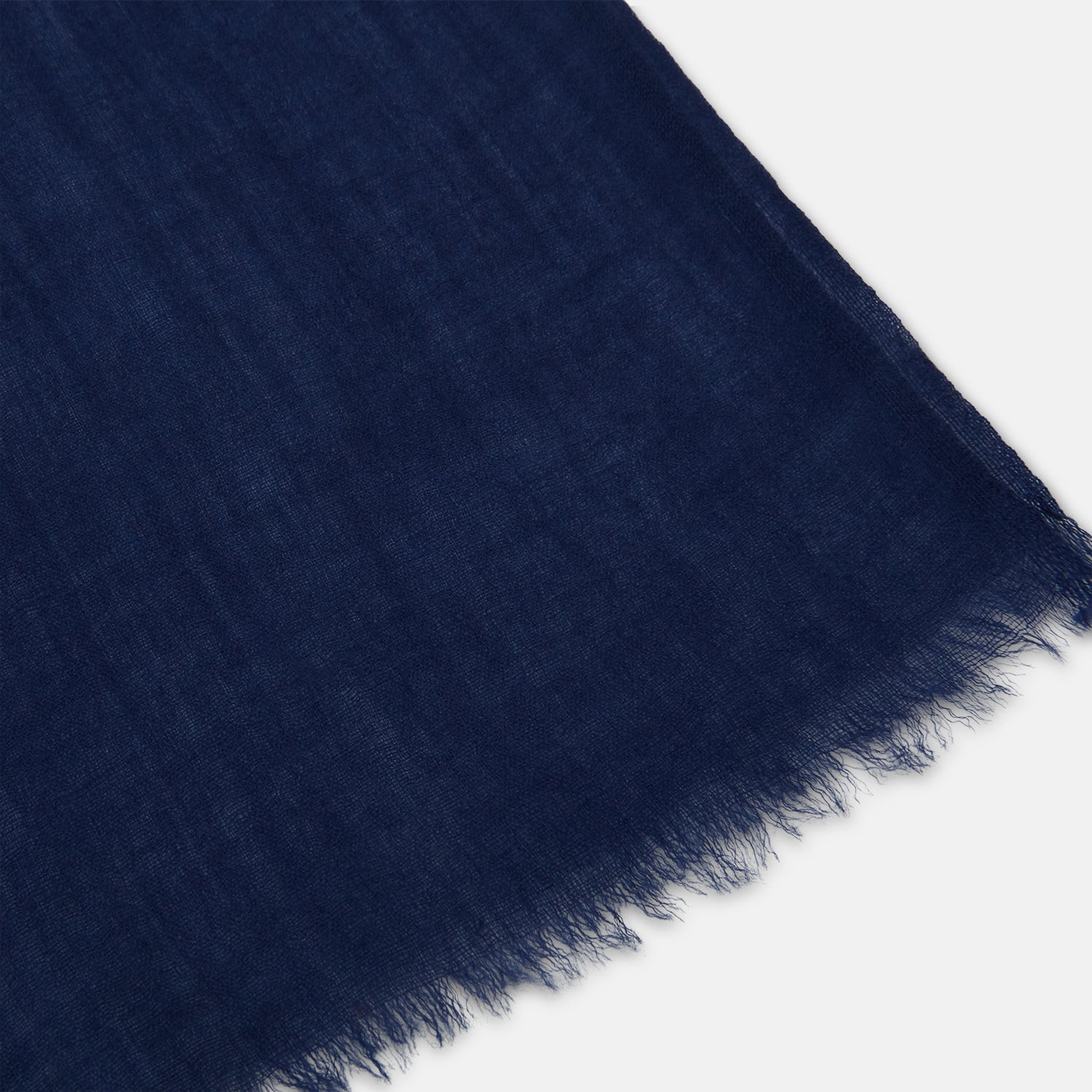 View 2 of product The Turnbull & Asser Navy Cashmere Scarf features a subtle texture and frayed edges, loosely knotted at the top and displayed against a plain white background.
