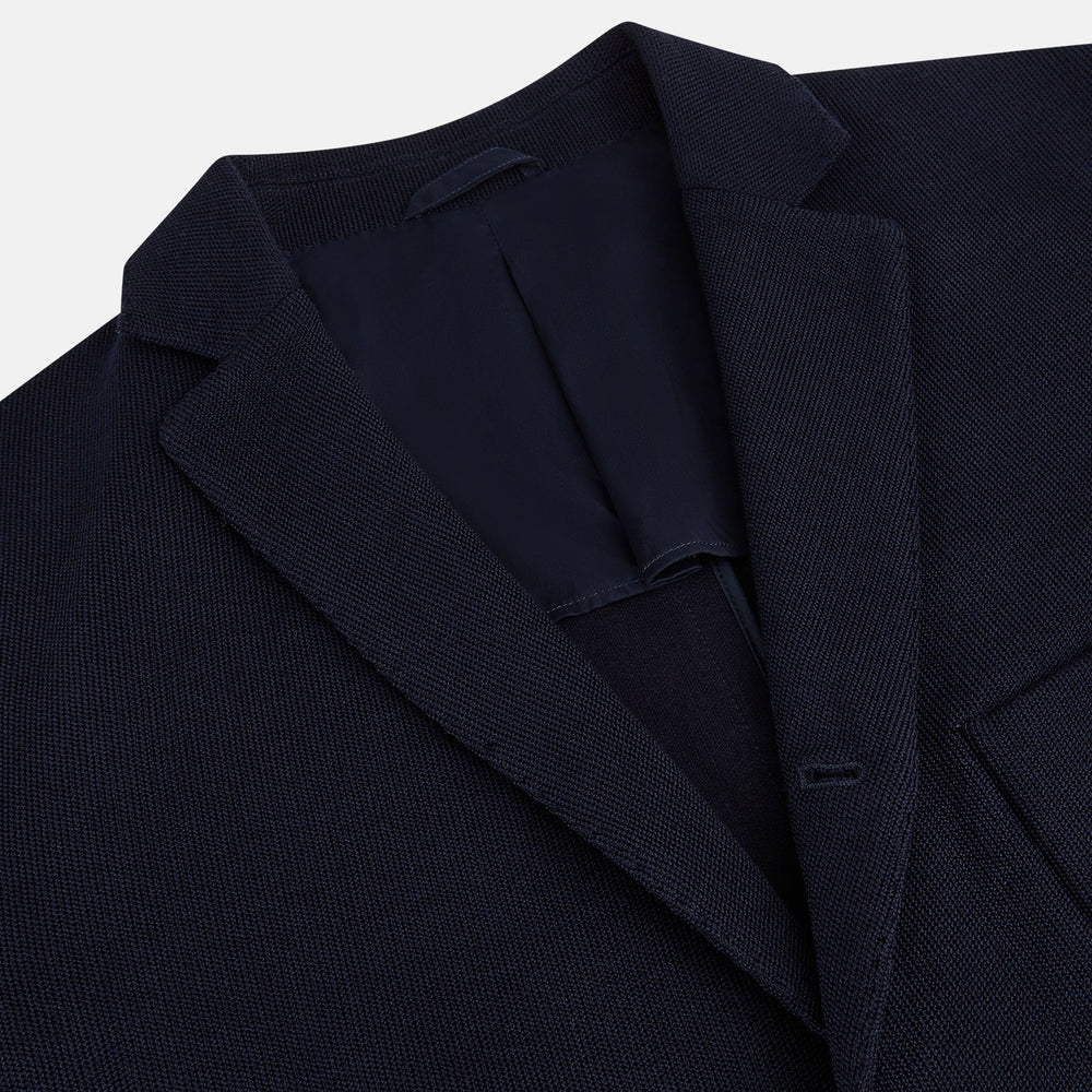 The Navy Knitted Oxford Blazer by Turnbull & Asser features notch lapels, two front buttons, a chest pocket, and two lower patch pockets, shown against a plain white background.