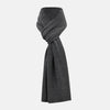 View 1 of product The Turnbull & Asser Plain Graphite Cashmere Knitted Scarf, draped and loosely knotted on a white background, showcases the refined elegance and timeless style of a luxury accessory.