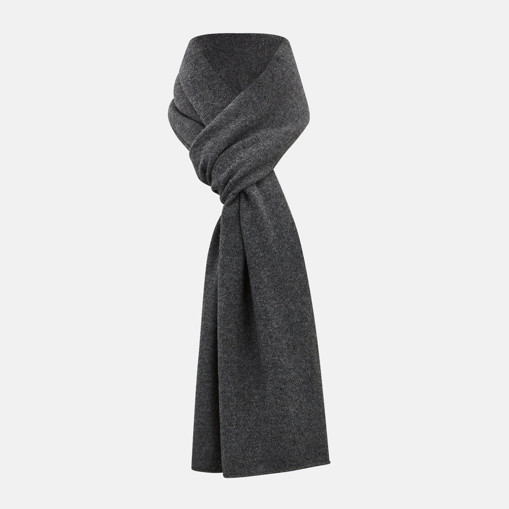 The Turnbull & Asser Plain Graphite Cashmere Knitted Scarf, draped and loosely knotted on a white background, showcases the refined elegance and timeless style of a luxury accessory.