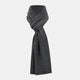 The Turnbull & Asser Plain Graphite Cashmere Knitted Scarf, draped and loosely knotted on a white background, showcases the refined elegance and timeless style of a luxury accessory.