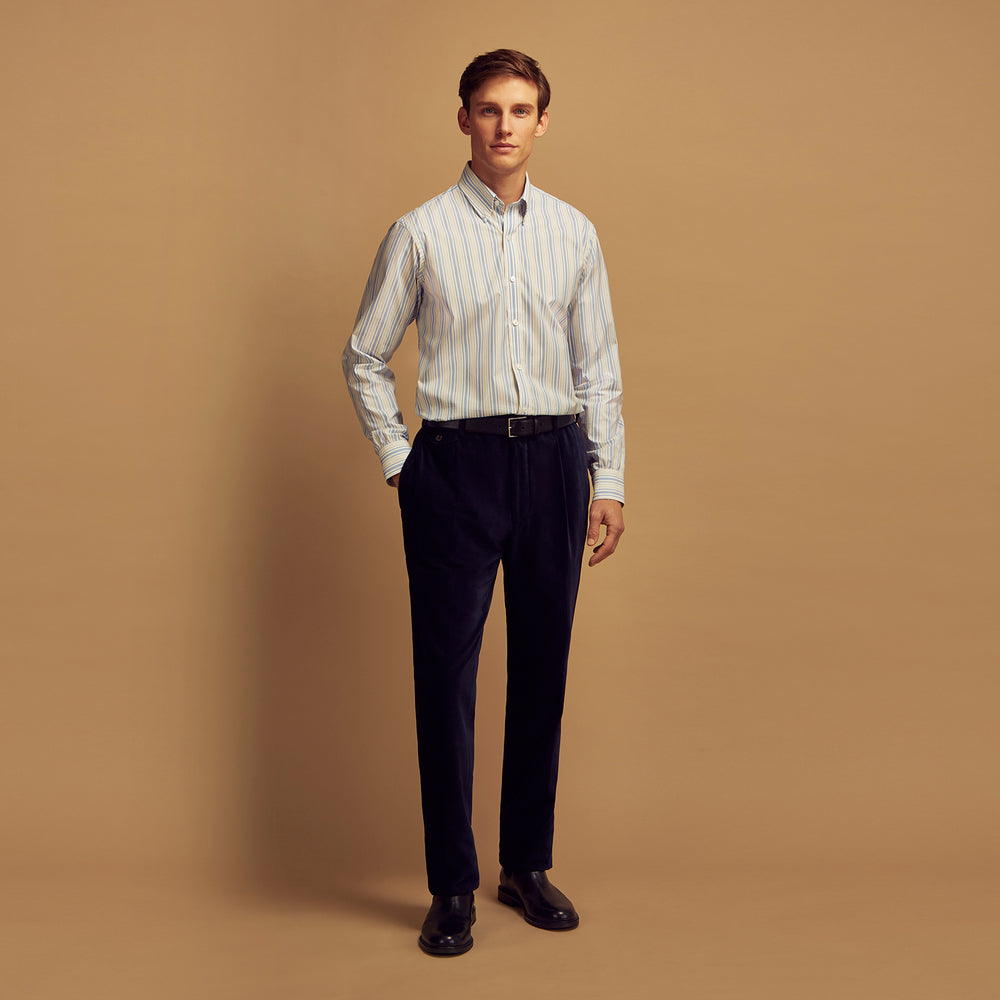 The Turnbull & Asser Blue Multi Stripe Wool Blend Weekend Fit Hayne Shirt features vertical blue, yellow, and white stripes, a button-down collar, and buttoned cuffs. Laid flat on a white background.