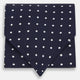 The White Dot and Navy Silk Cravat by Turnbull & Asser features evenly spaced white polka dots on navy silk—a classic accessory ideal for adding British elegance to any look.