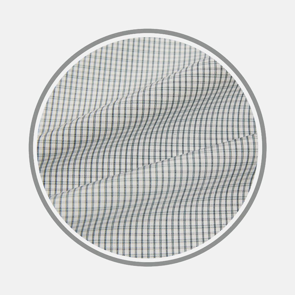 Close-up of Turnbull & Asser's Forest Green Tattersall Fabric, showing a grid pattern of thin blue and gray lines forming small squares. The white fabric appears slightly wrinkled within a circular frame against a plain background.