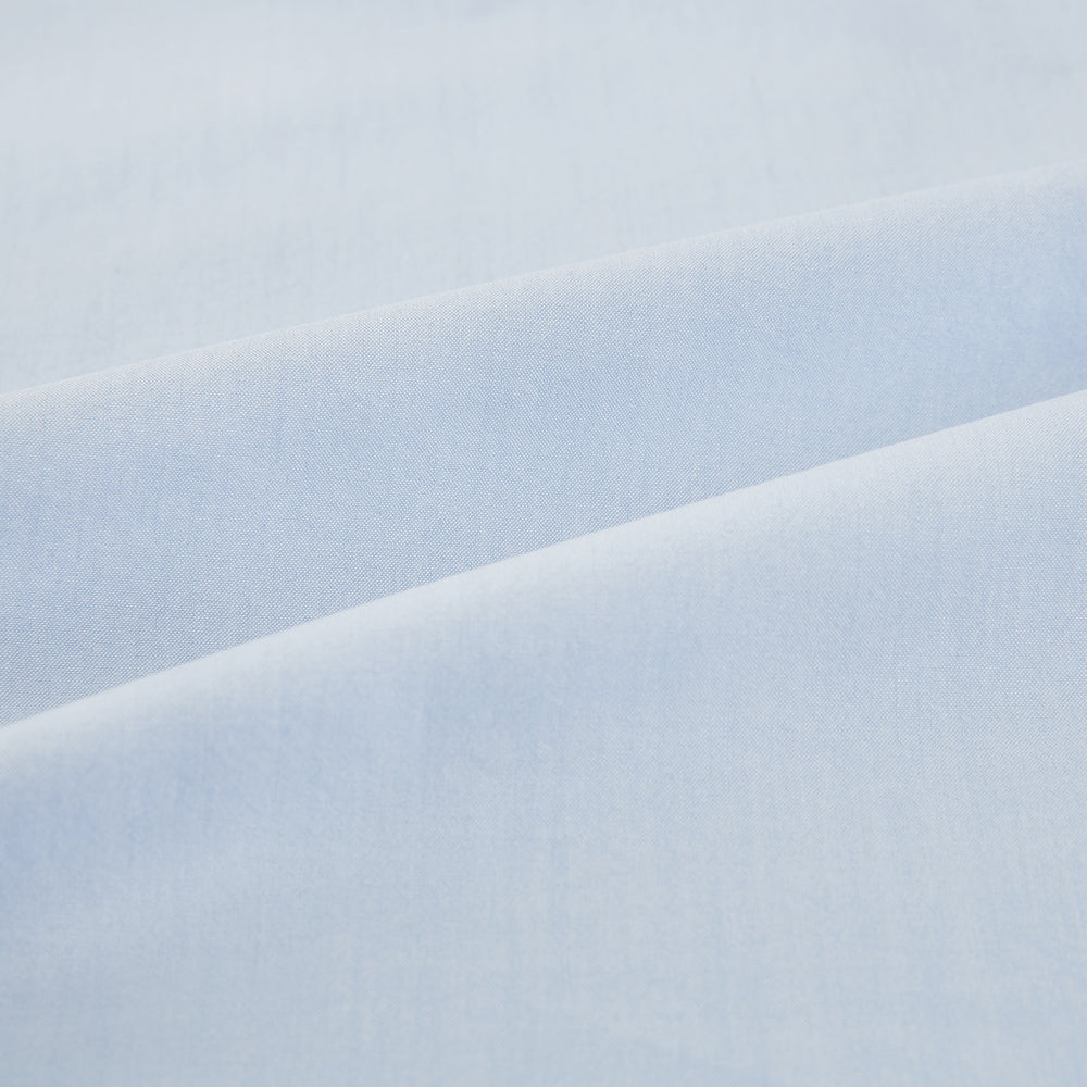 The Pale Blue Mayfair Shirt by Turnbull & Asser is a long-sleeve, button-up dress shirt with a pointed collar and buttoned cuffs, crafted from sanforised cotton and shown laid flat on a white background.