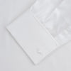 View 4 of product The Turnbull & Asser White Herringbone Sea Island Quality Cotton Shirt features a T&A collar, double cuffs, and chest pocket. Crafted for luxury with a classic design, it’s shown neatly folded against a light grey background—ideal for evening wear.