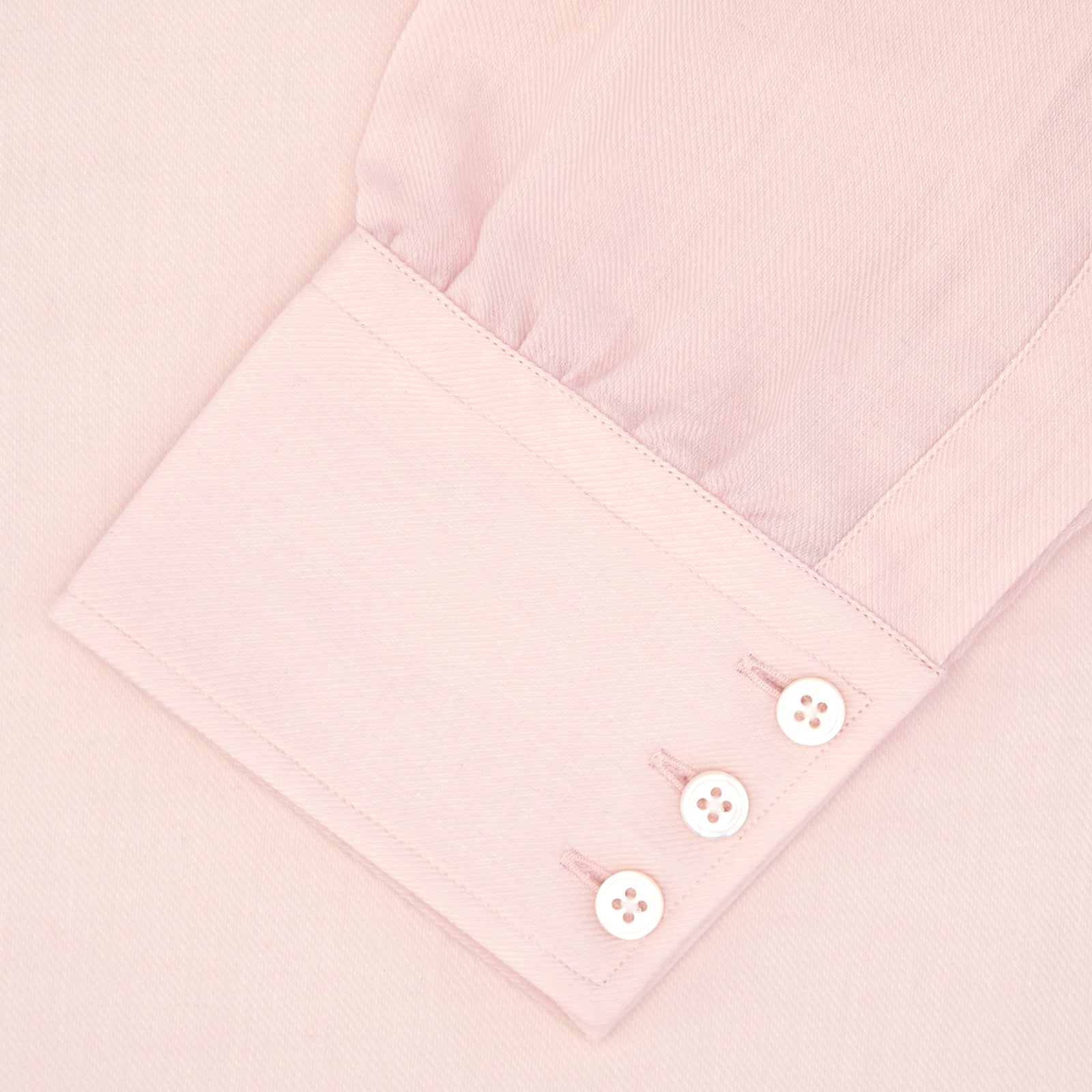 View 4 of product The Turnbull & Asser Pink Cashmere Blend Shirt features a T&A collar and 3-button cuffs, neatly folded with white buttons, displayed on a plain white background.