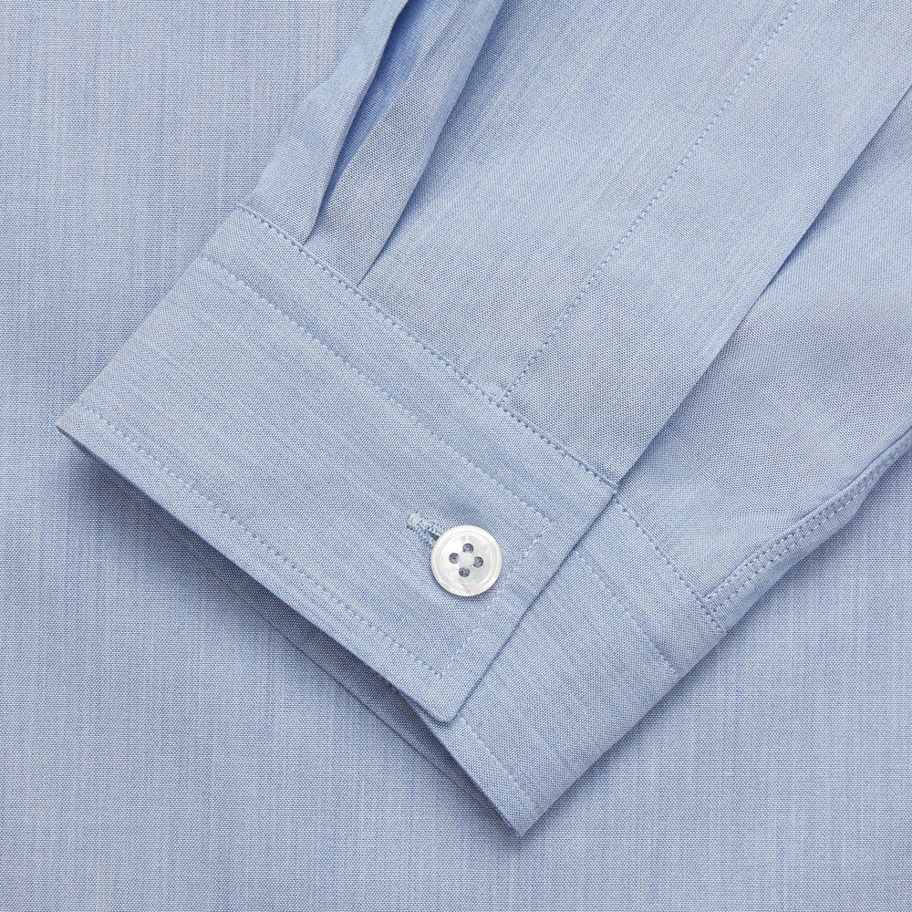 The Turnbull & Asser Slate Blue Chambray Holiday Fit Fellows Shirt features long sleeves and a classic collar, laid flat on a white background—a versatile summer piece for any occasion.