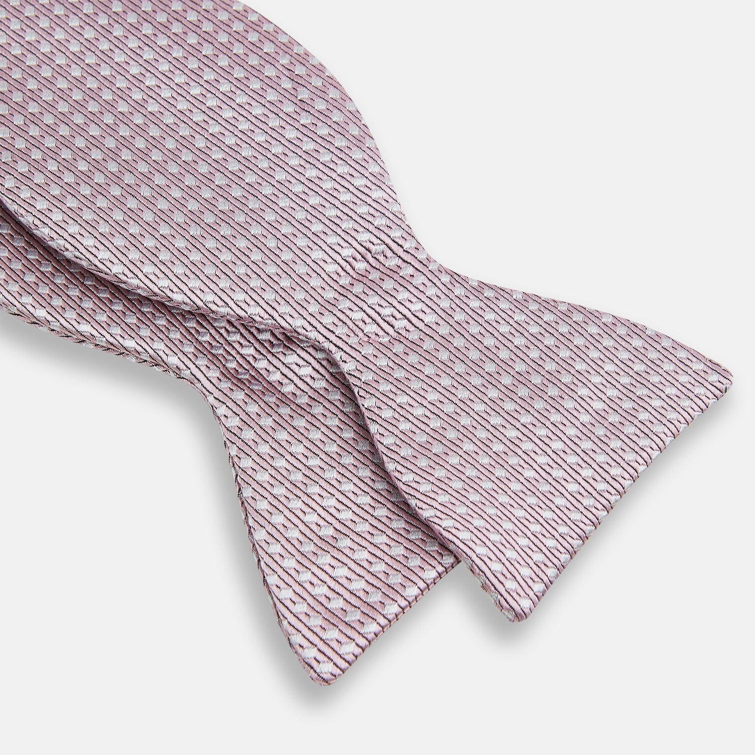 View 3 of product The Turnbull & Asser Pale Pink and White Square Silk Bow Tie features white stripes and subtle square patterns, ideal for formalwear. Shown on a white background.