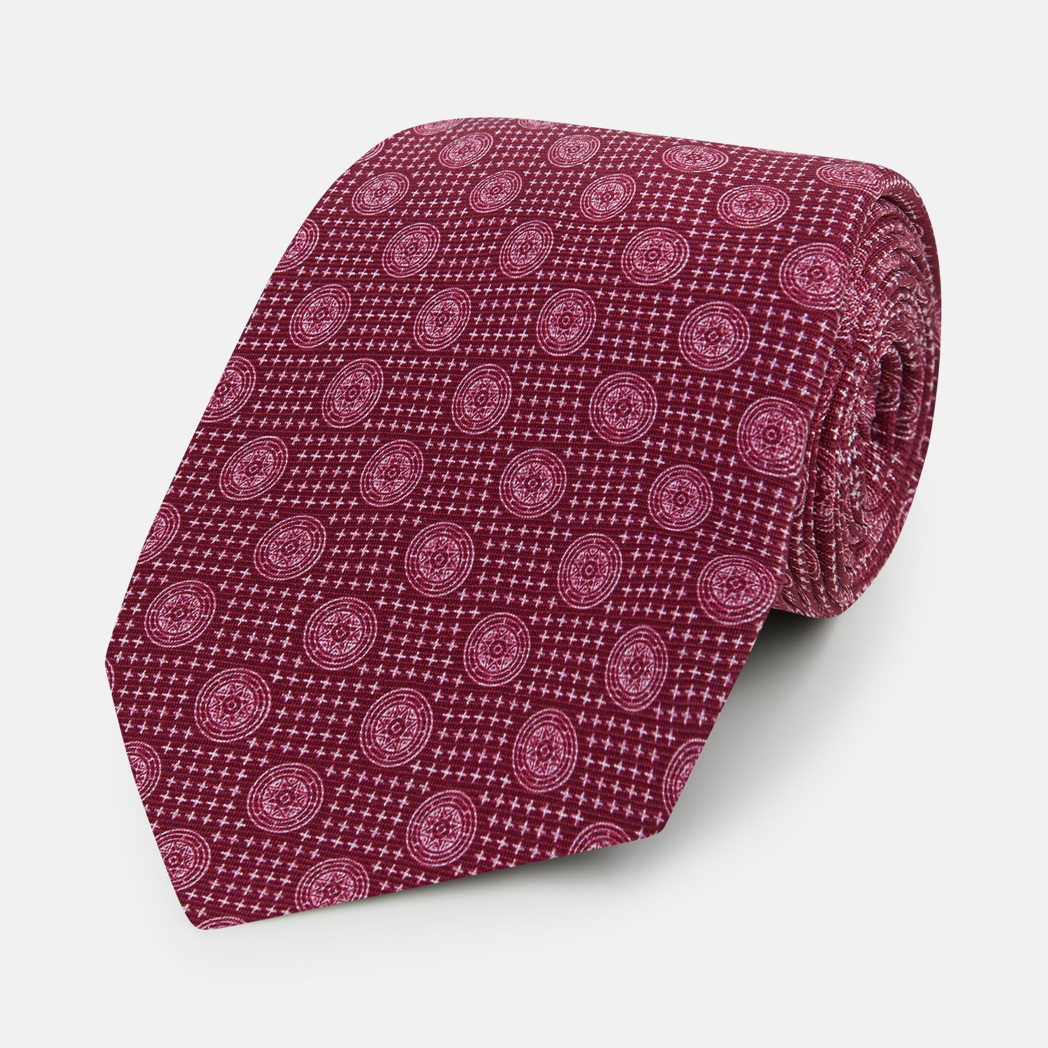 View 1 of product The Turnbull & Asser Burgundy Medallion Silk Tie features a geometric pattern of small circles intersected by diagonal pink lines, elegantly displayed against a white background.