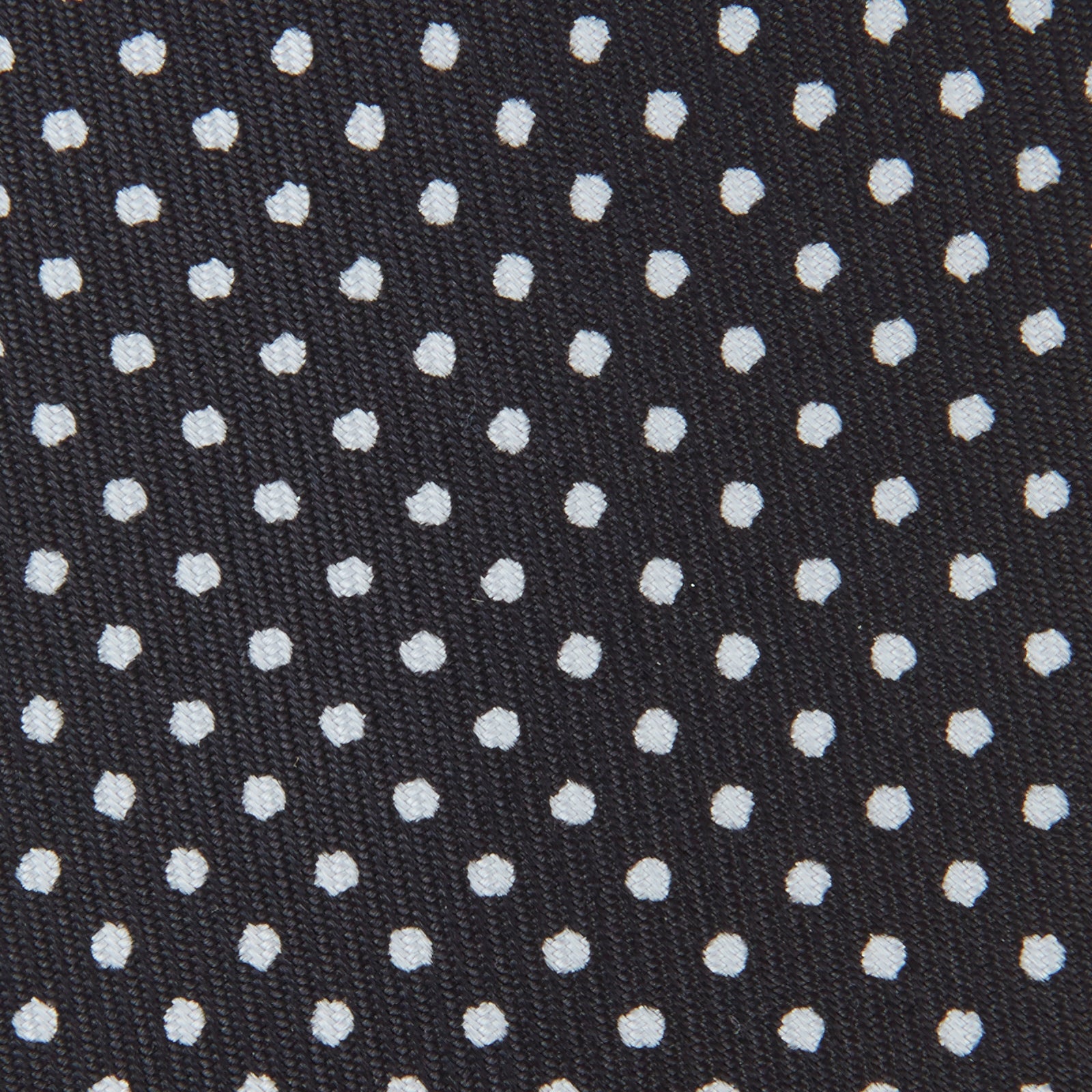 View 3 of product The Turnbull & Asser Black and White Small Spot Printed Silk Tie, shown rolled against a white background, features a subtle polka dot pattern—an ideal accessory for any office shirt.