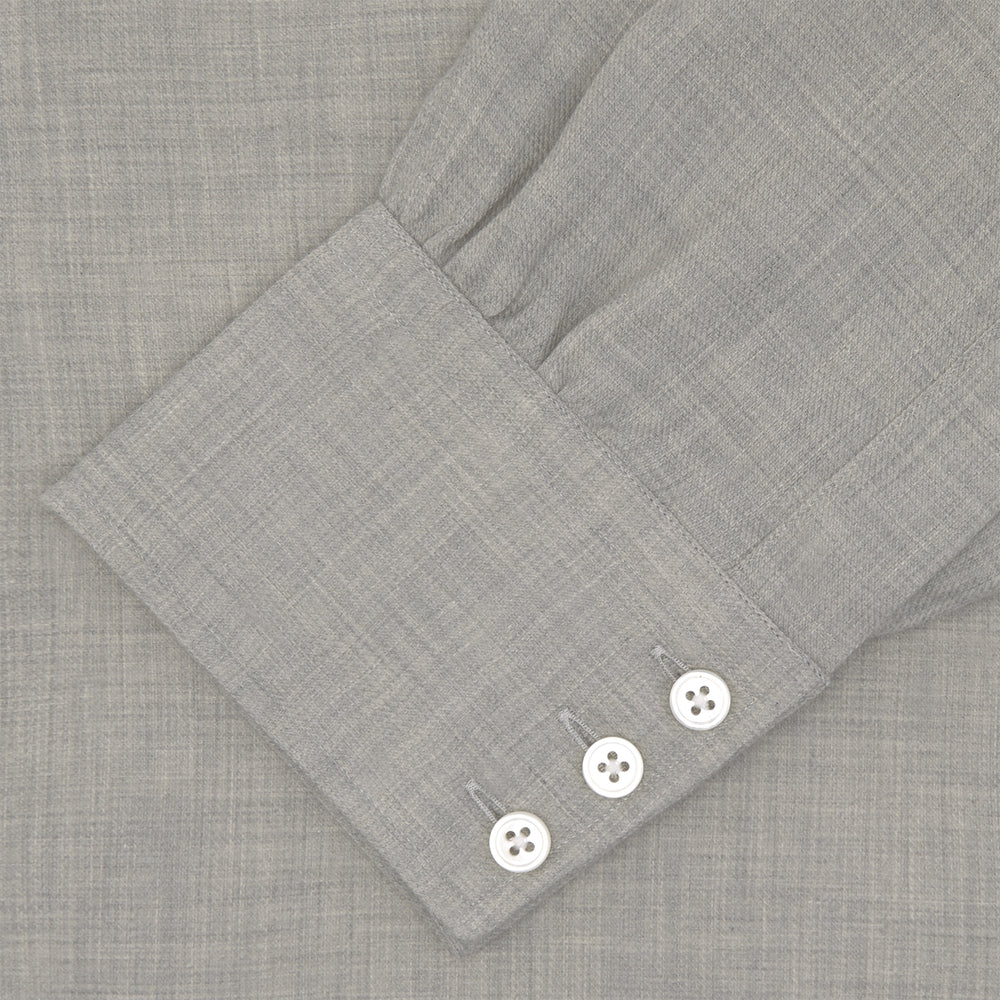 The Turnbull & Asser Grey Cashmere Blend Shirt features a T&A collar, 3-button cuffs, and a front pocket, shown neatly folded with white buttons against a plain white background.