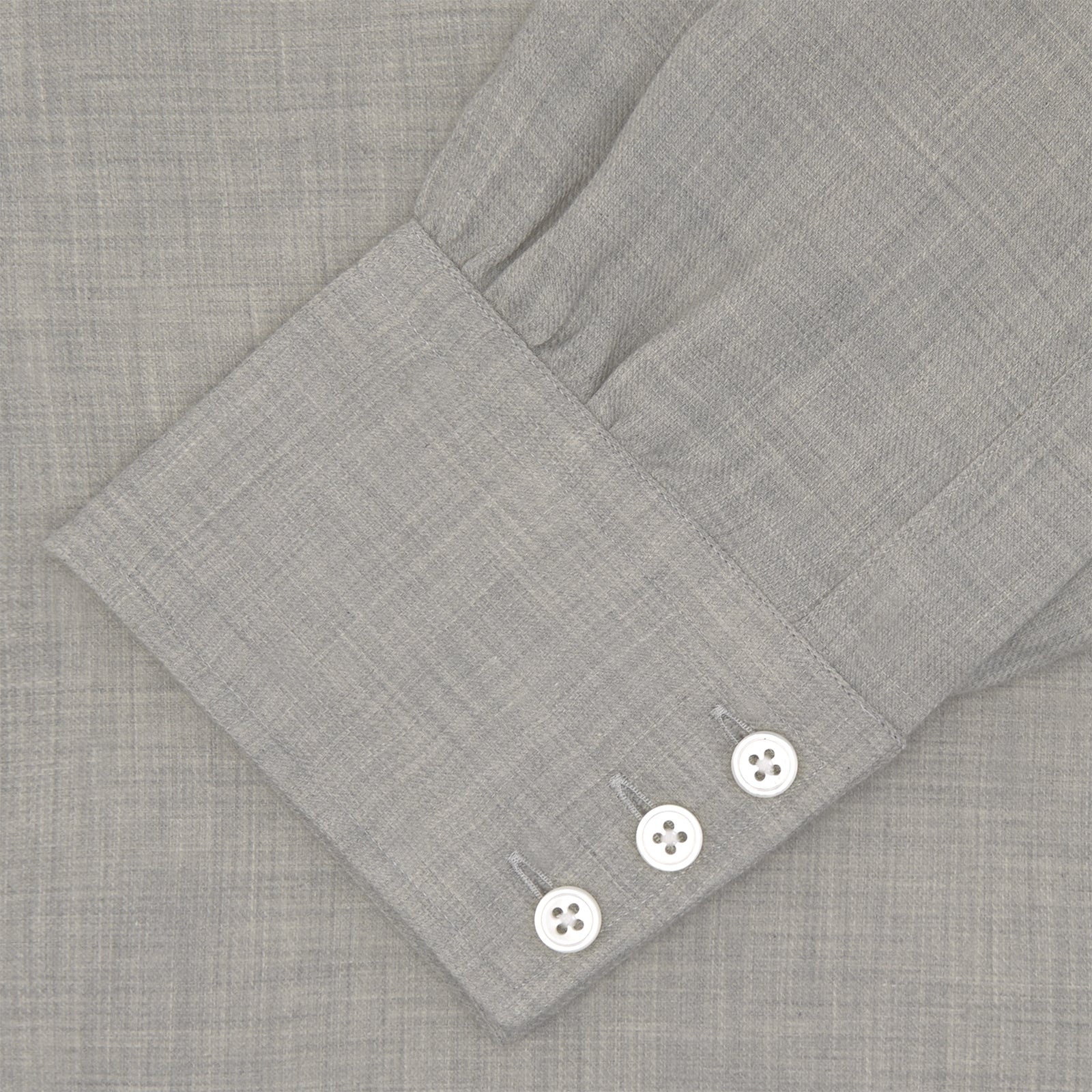 View 4 of product The Turnbull & Asser Grey Cashmere Blend Shirt features a T&A collar, 3-button cuffs, and a front pocket, shown neatly folded with white buttons against a plain white background.