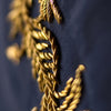 View 4 of product The Turnbull & Asser Navy Gold Embroidered Botanical Tie features intricate gold botanical embroidery on navy blue silk, neatly rolled with the detailed tip facing forward.