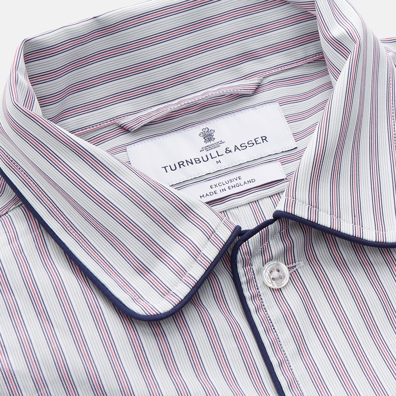 View 4 of product The Turnbull & Asser Red and Blue Multi Stripe Cotton Sussex Nightshirt features long sleeves, a knee-length cut, collared neckline, button placket, chest pocket with dark trim, and rounded hem for luxurious sleepwear.