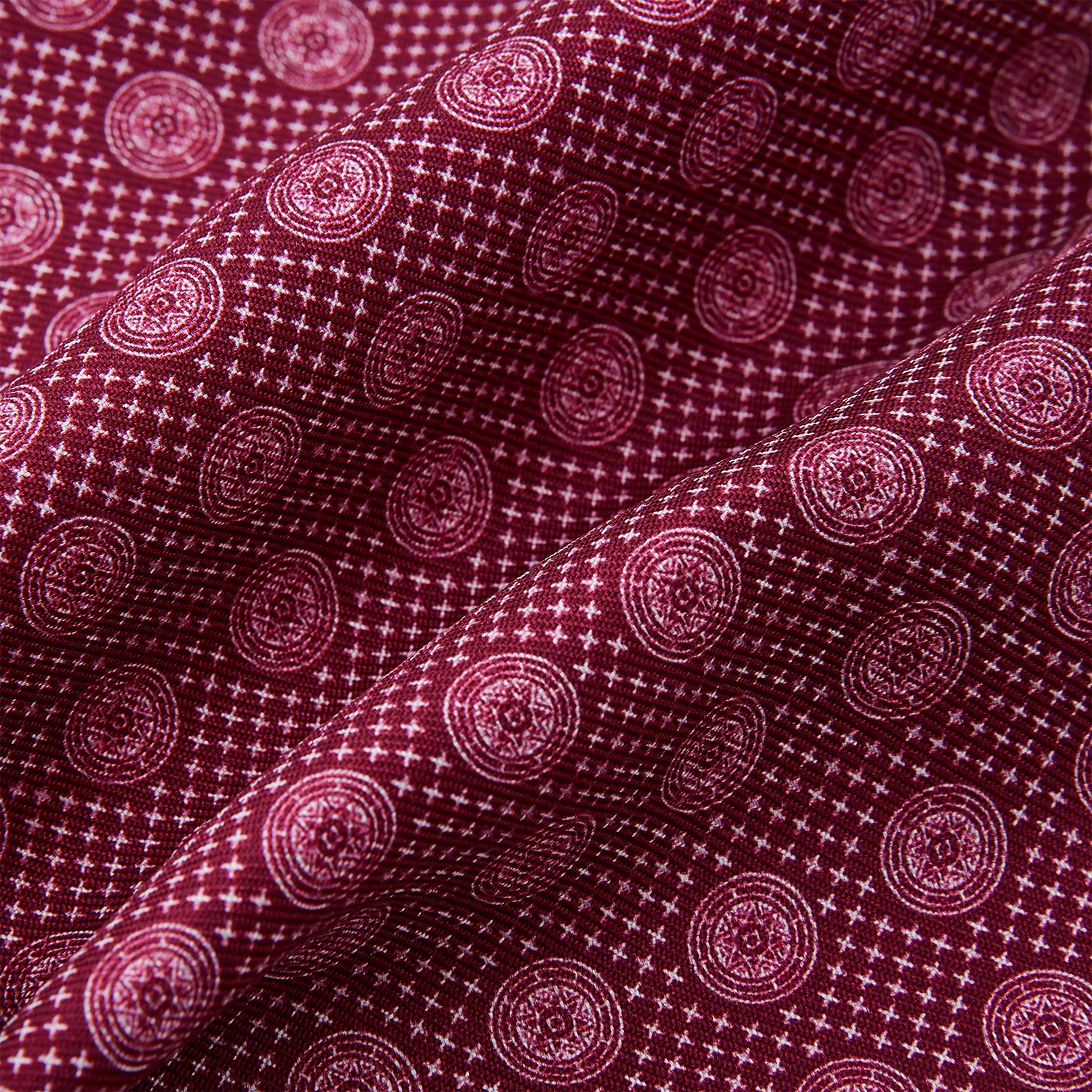 View 4 of product The Burgundy Medallion Silk Cravat by Turnbull & Asser features a white geometric medallion pattern, neatly crafted for an elegant accessory inspired by classic British style.
