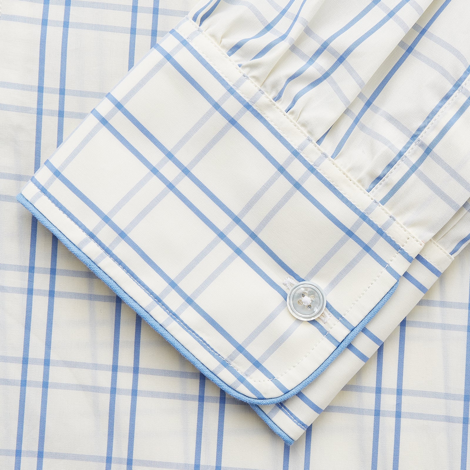 View 3 of product The Turnbull & Asser Cream Multi Cotton Sussex Nightshirt is a knee-length, long-sleeve shirt dress with a blue and beige plaid pattern, collar, front button placket, chest pocket, and rounded hem with side slits.