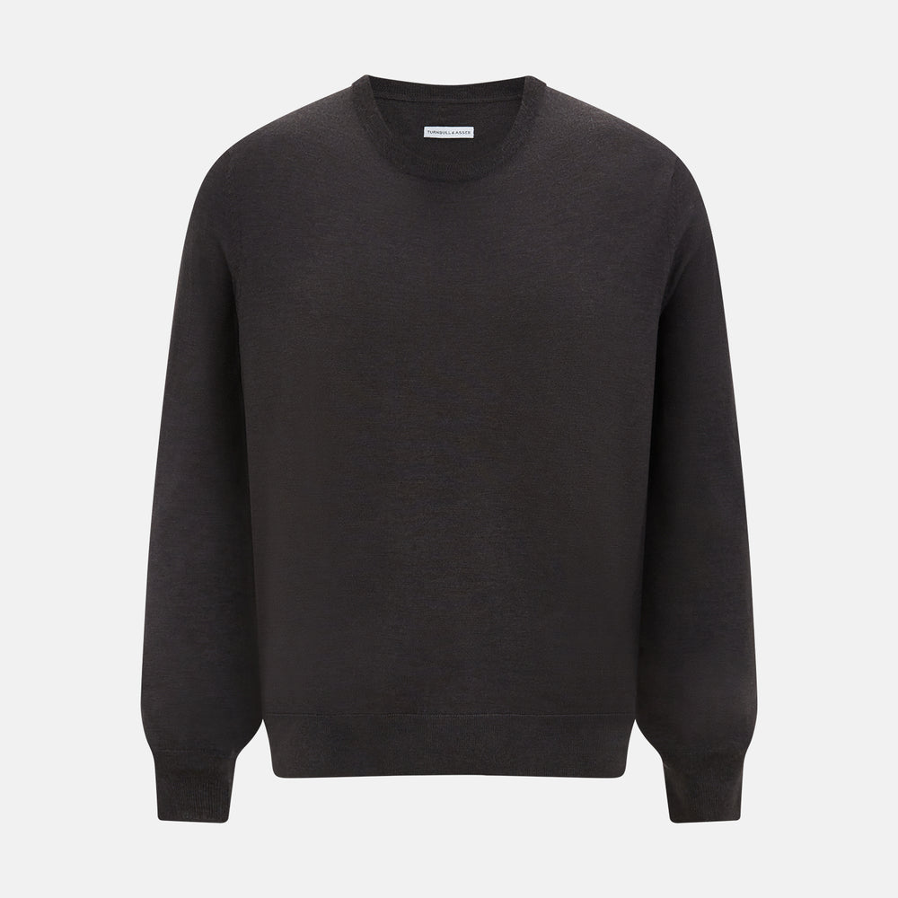 The Turnbull & Asser Charcoal Grey Fine Merino Round Neck Jumper for men features long sleeves, ribbed cuffs, hem, and collar. Displayed on a white background, this classic knitwear piece has a plain design with no visible logos or patterns.
