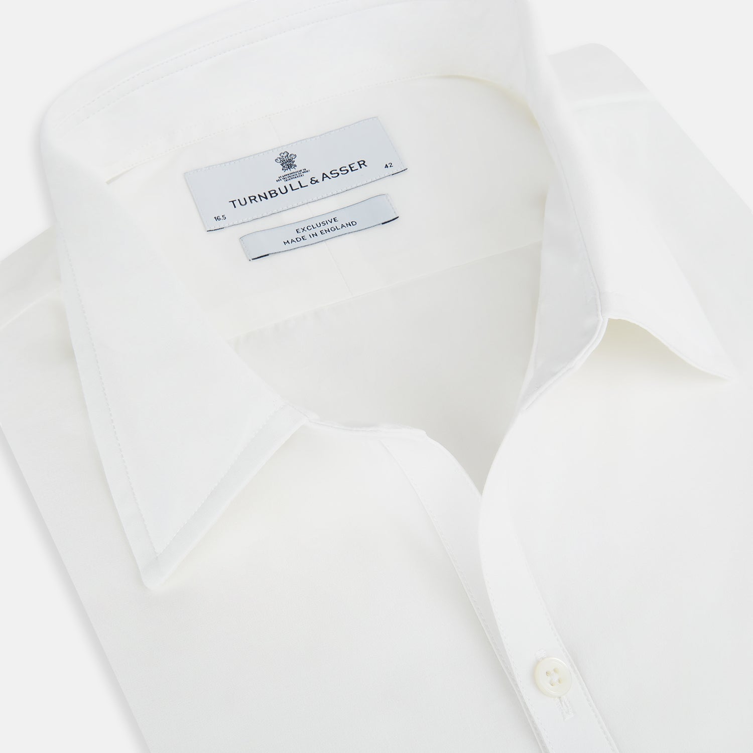 View 2 of product The Turnbull & Asser Plain White Windsor Shirt features a Turnbull open collar, 3-button cuffs, and relaxed fit—exemplifying British craftsmanship. Displayed on a white background.