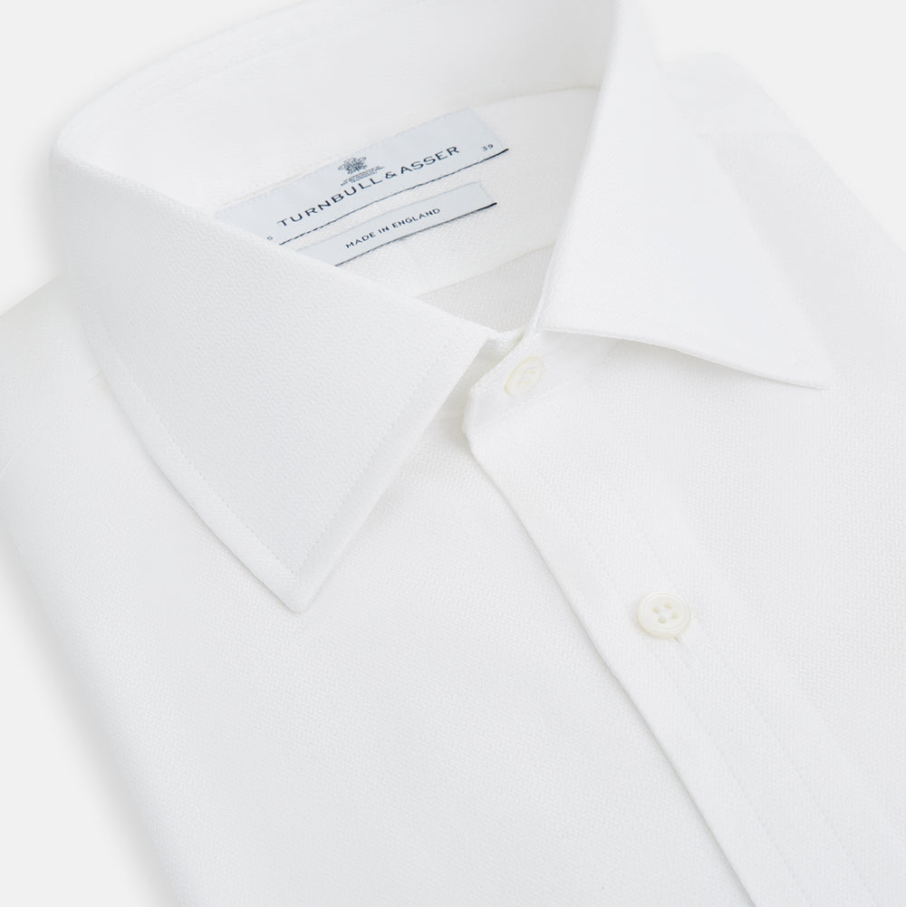 The Turnbull & Asser White Herringbone Mayfair Shirt features long sleeves and a classic collar—a timeless wardrobe essential, shown here against a white background.