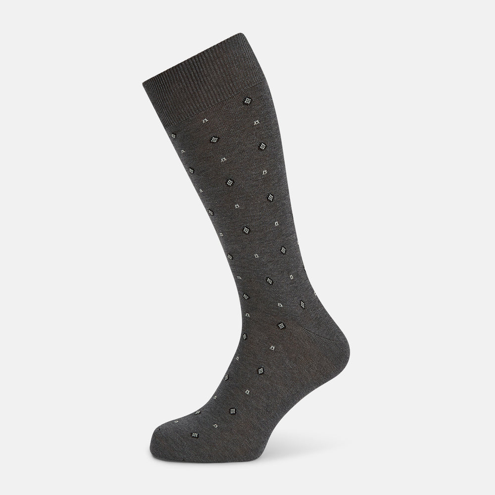 The Grey Patterned Mid-Length Socks by Turnbull & Asser are crafted from soft Egyptian cotton, with a ribbed cuff and small white diamond shapes on a grey background.