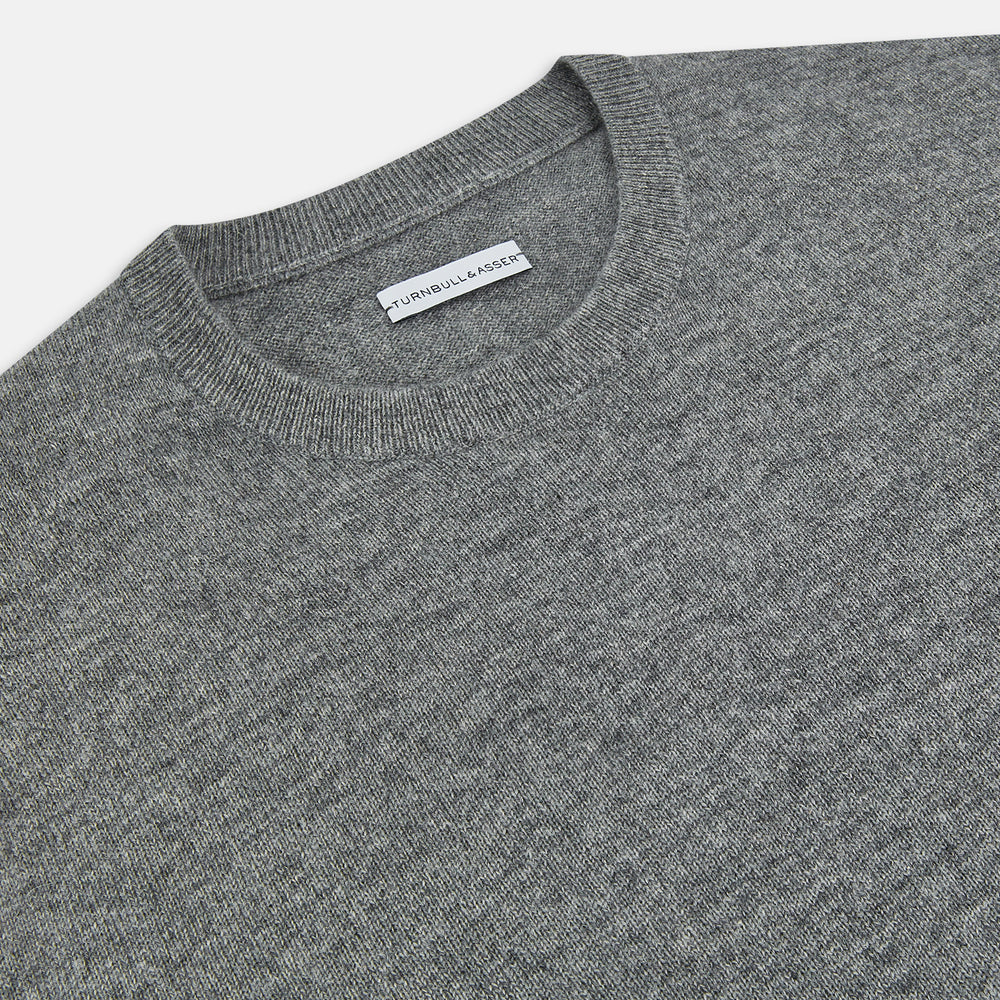The Turnbull & Asser Grey Melange Cashmere Round Neck Jumper for men features a classic crewneck design with ribbed cuffs, hem, and neckline, displayed against a white background.