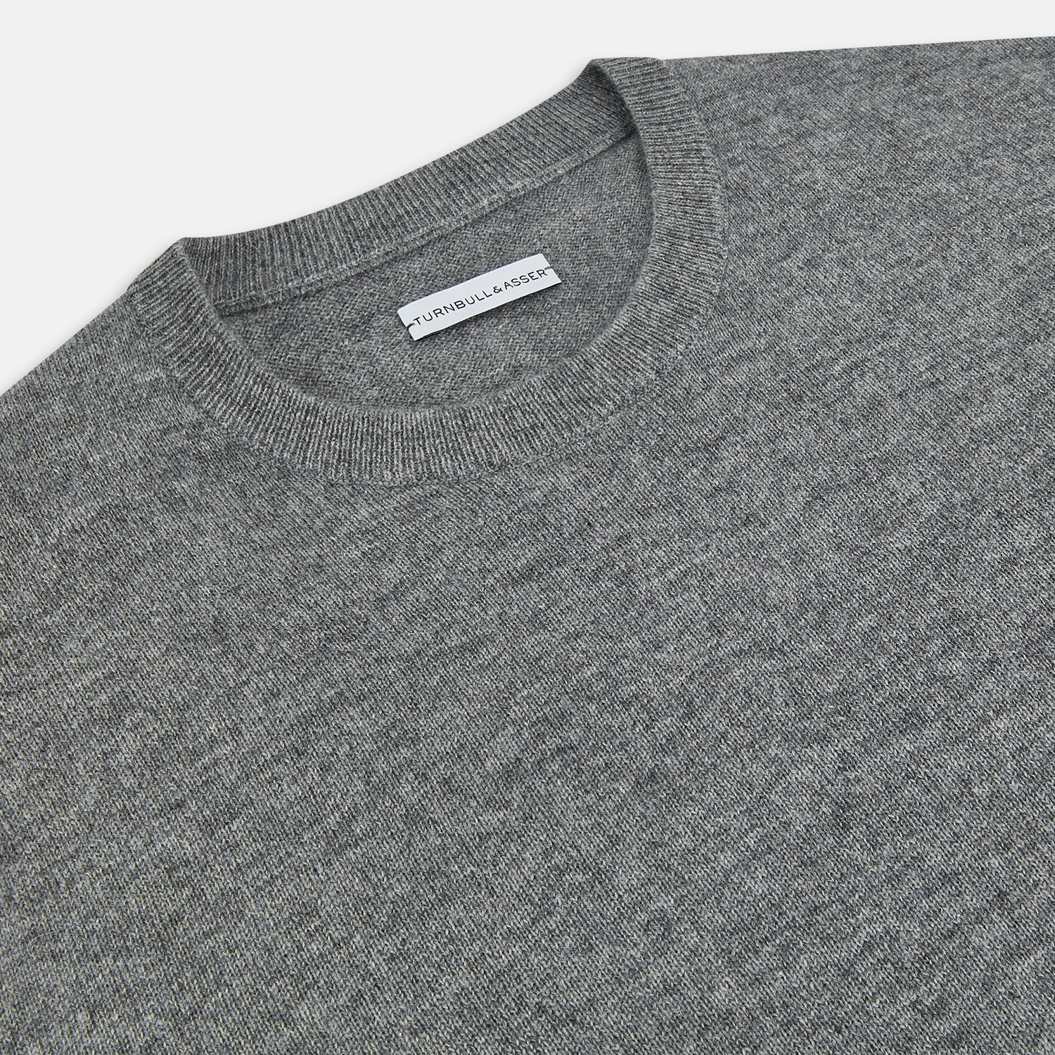 View 2 of product The Turnbull & Asser Grey Melange Cashmere Round Neck Jumper for men features a classic crewneck design with ribbed cuffs, hem, and neckline, displayed against a white background.