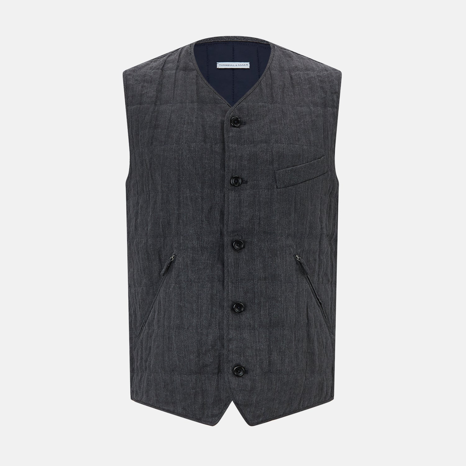 View 1 of product The Turnbull & Asser Ash Quilted Linen Herringbone Waistcoat is sleeveless and dark gray with a V-neck, two zippered side pockets, and a small chest pocket, shown on a plain white background.