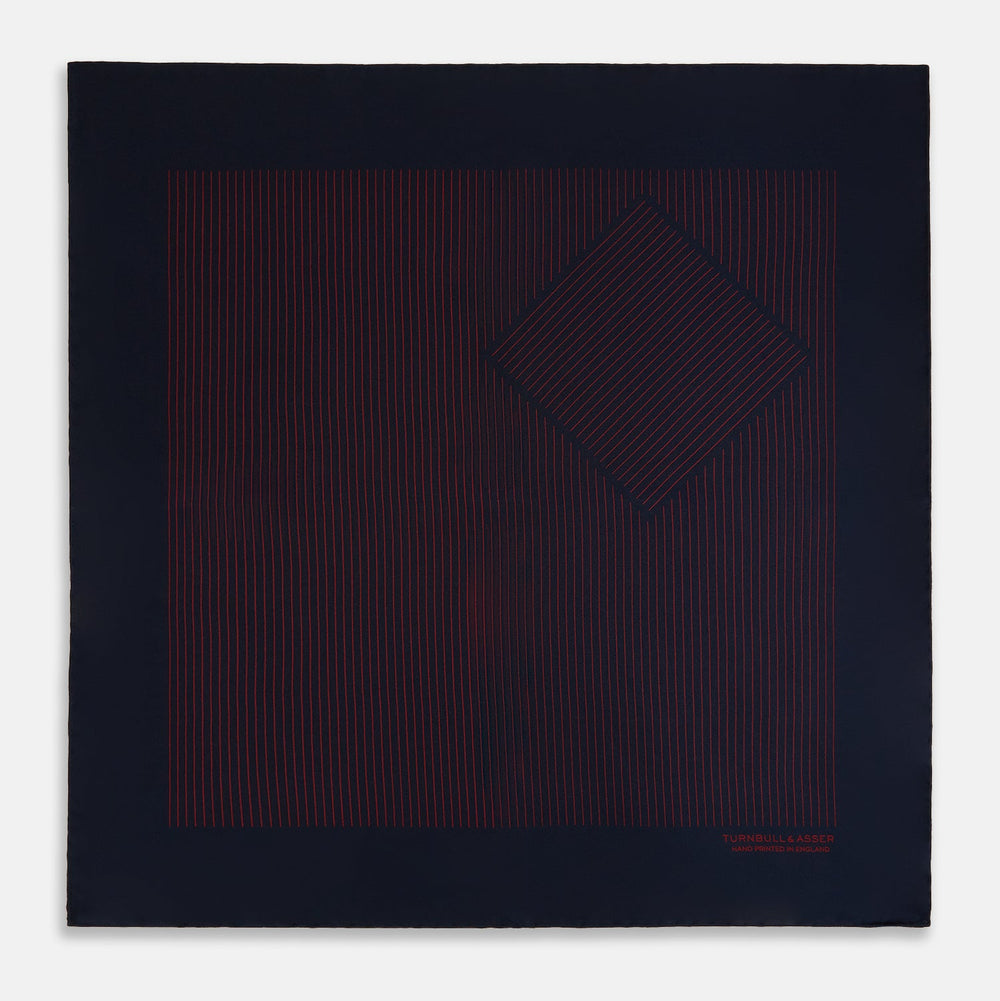 The Turnbull & Asser Navy and Burgundy Stripe Silk Pocket Square features diagonal stripes in one corner, hand-rolled edges, and "TURNBULL & ASSER HAND PRINTED IN ENGLAND" printed in red on luxurious silk.