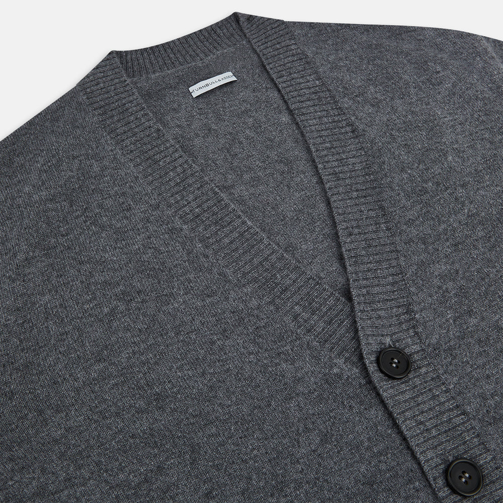 The Turnbull & Asser Grey Melange Cashmere Cardigan features a V-neck, ribbed cuffs and hem, front buttons, and two pockets—an elegant piece from our timeless knitwear collection. Shown here against a plain white background.