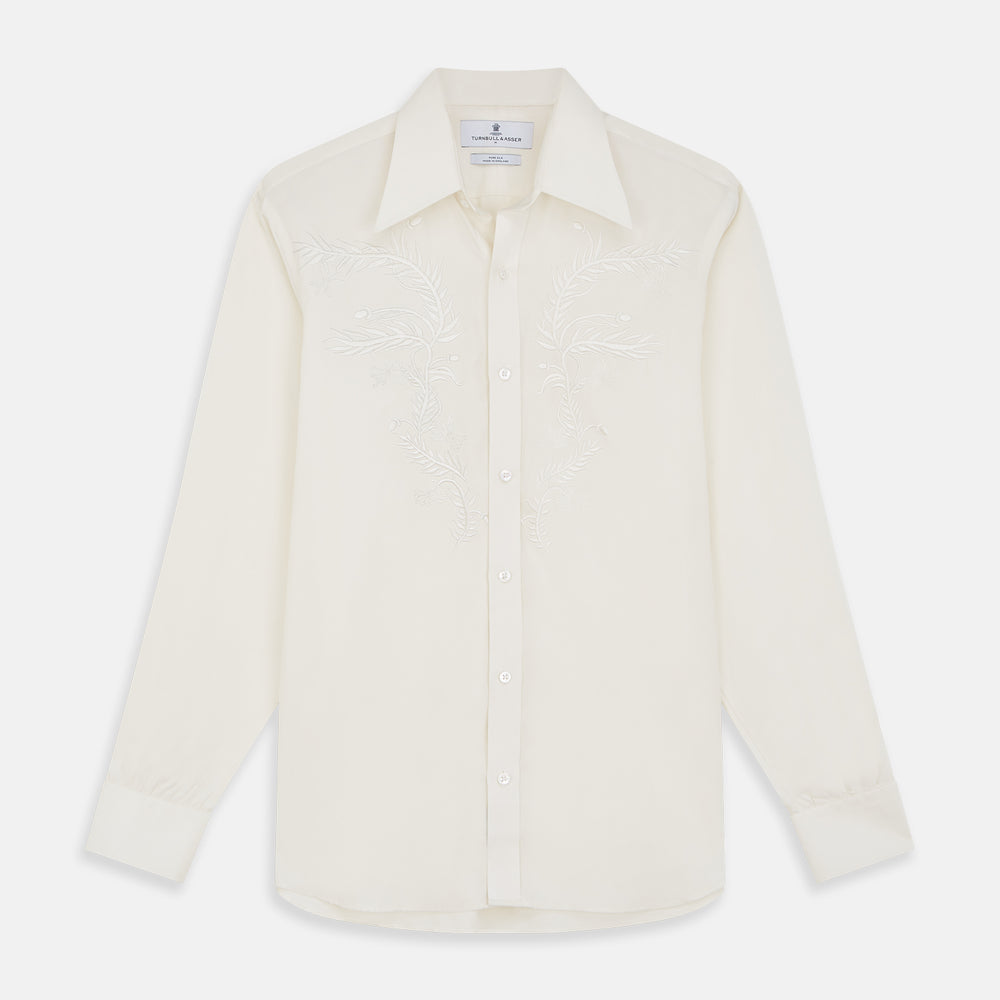The Cream Silk Long Point Embroidered Eamon Shirt by Turnbull & Asser features long sleeves, a pointed collar, and delicate botanical embroidery. Its buttoned cuffs and tailored fit make it an elegant partywear choice.
