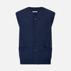 View 1 of product The NAVY MERINO V-NECK SLEEVELESS CARDIGAN by Turnbull & Asser features a button-down front, ribbed edges, and two front pockets—an elegant layering piece for stylish menswear.