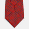 View 3 of product The Turnbull & Asser Red and Blue Square-Patterned Silk Tie is rolled up on a plain white background.